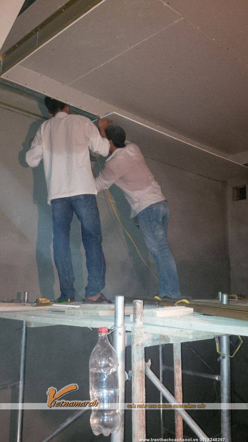  Đội thợi thi công đang tiến hành lắp đặt những tấm thạch cao lên trần nhà